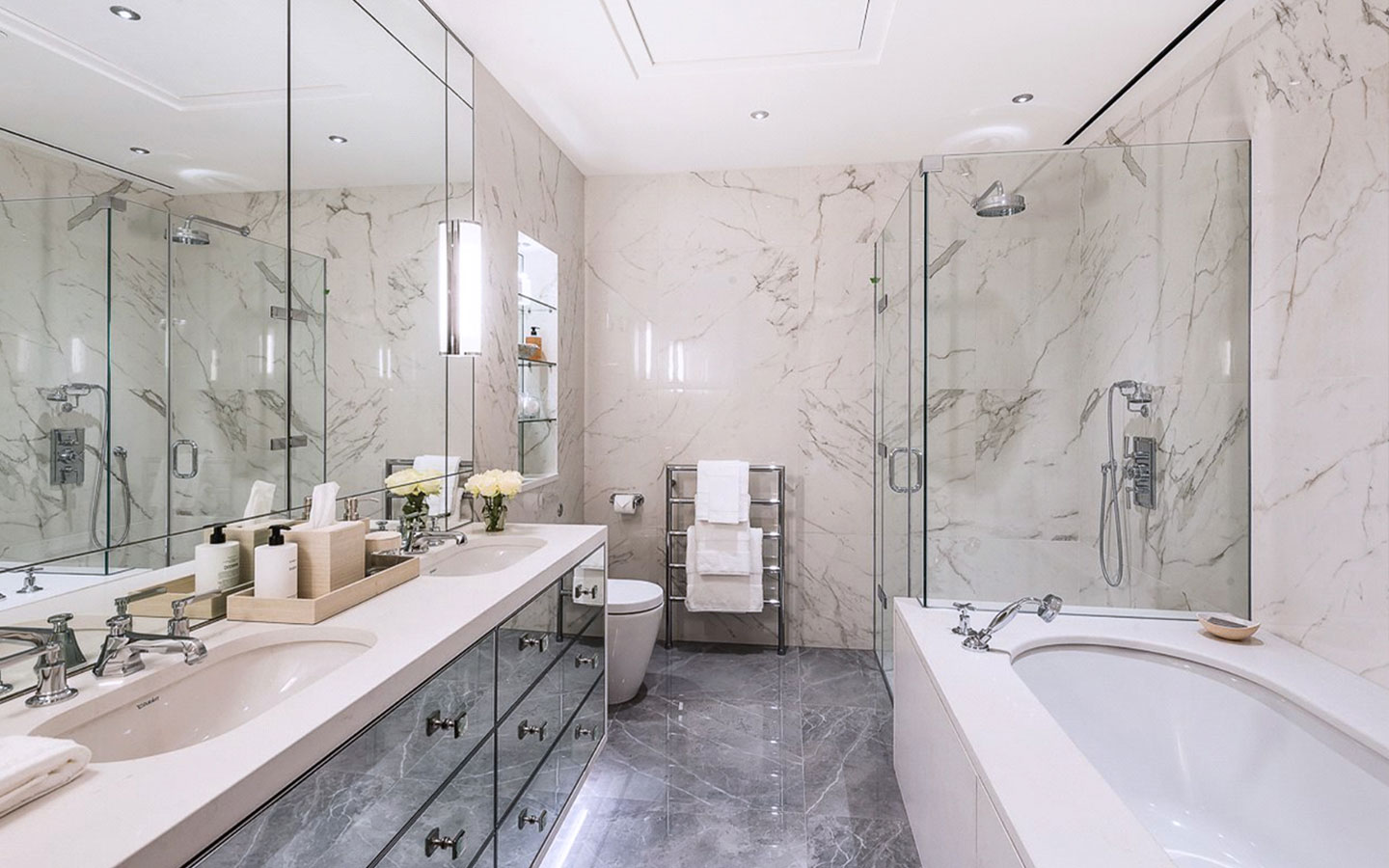 Custom designed double vanity and bathtub surround clad with Frosty Carrina quartz stone
