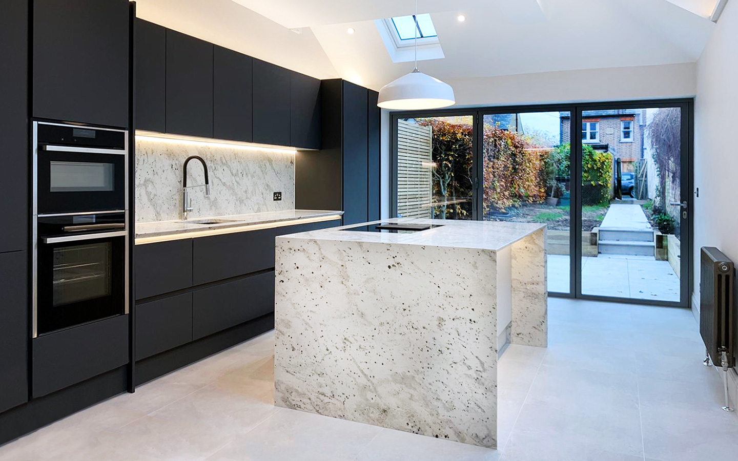 Black contemporary kitchen with andromeda white granite kitchen worktop